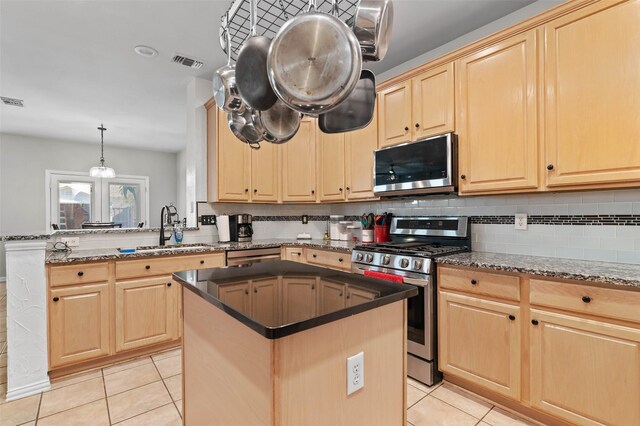 kitchen with a center island, sink, stainless steel appliances, decorative light fixtures, and light brown cabinetry