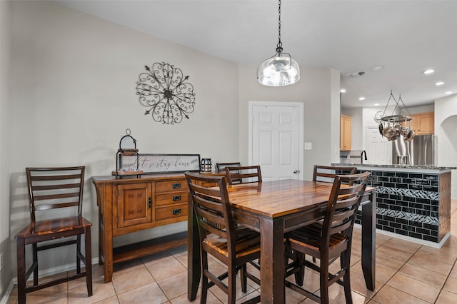 tiled dining room featuring sink