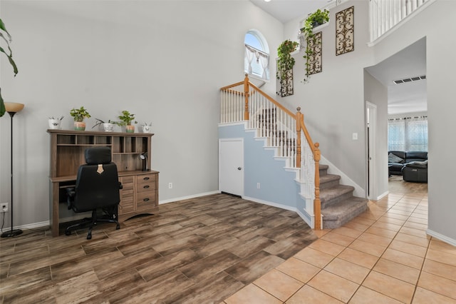 office with a high ceiling and wood-type flooring