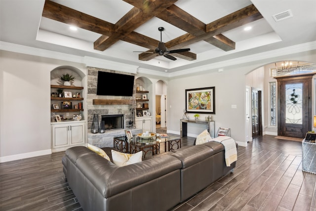 living room featuring beamed ceiling, dark hardwood / wood-style floors, a stone fireplace, and coffered ceiling