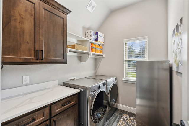 clothes washing area with cabinets, dark hardwood / wood-style floors, and washer and clothes dryer