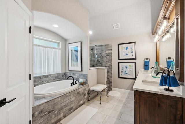 bathroom featuring plus walk in shower, vanity, and tile patterned floors