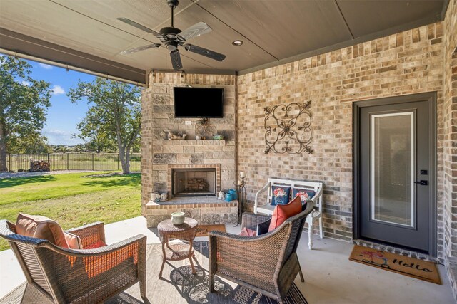 view of patio / terrace featuring an outdoor stone fireplace and ceiling fan