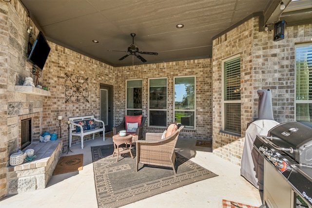 view of patio / terrace featuring an outdoor living space with a fireplace, ceiling fan, and area for grilling