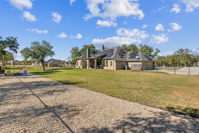 view of front of home with a front yard and solar panels