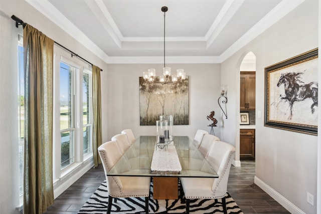 dining room with dark hardwood / wood-style flooring, a tray ceiling, and ornamental molding