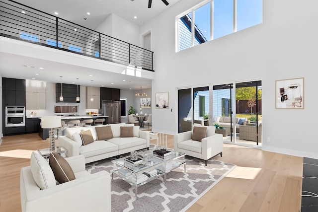 living room with a towering ceiling, light hardwood / wood-style flooring, and a wealth of natural light