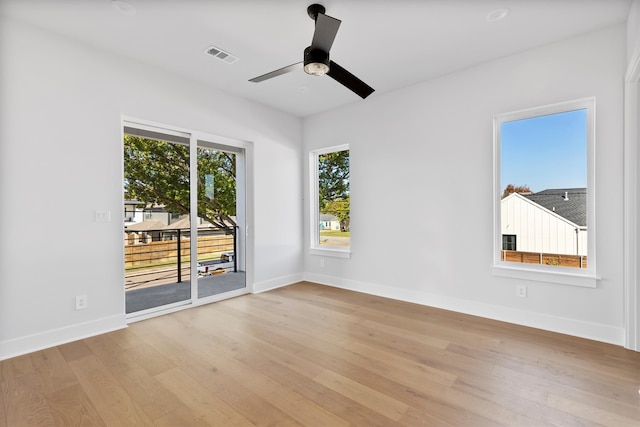 unfurnished room with light hardwood / wood-style floors, a wealth of natural light, and ceiling fan