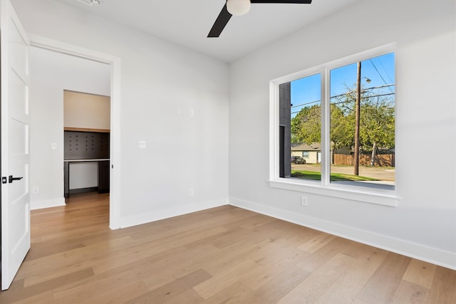 empty room with ceiling fan and light hardwood / wood-style floors