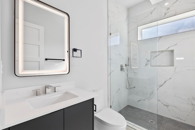 bathroom featuring tiled shower, vanity, and toilet