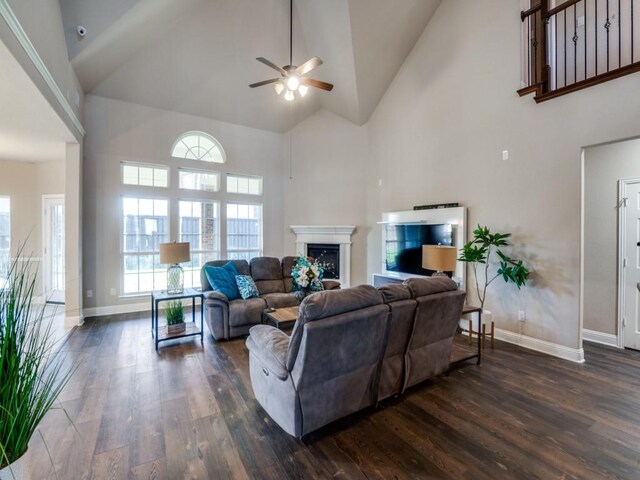 living room with ceiling fan, high vaulted ceiling, and dark hardwood / wood-style floors