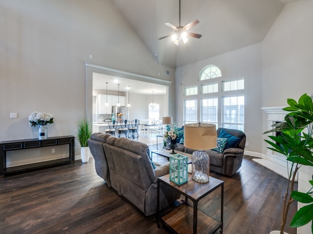 living room with high vaulted ceiling, ceiling fan, and dark wood-type flooring