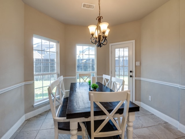 tiled dining area featuring an inviting chandelier and a wealth of natural light