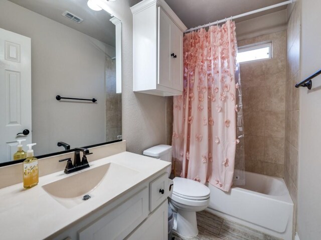 full bathroom featuring vanity, toilet, and shower / tub combo with curtain