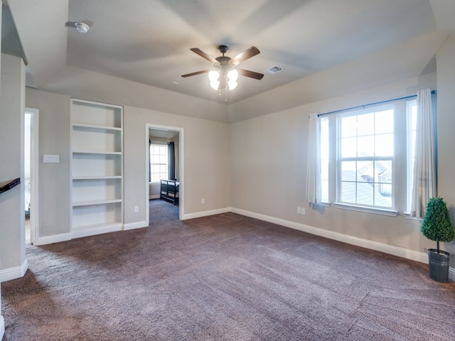 unfurnished bedroom with dark colored carpet and ceiling fan