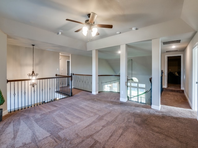 carpeted spare room with ceiling fan with notable chandelier