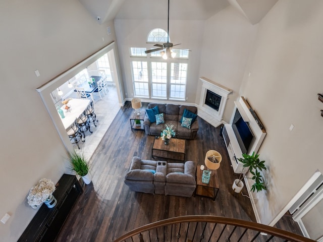 living room with hardwood / wood-style floors, ceiling fan, and high vaulted ceiling