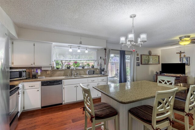 kitchen with white cabinetry, sink, stainless steel appliances, and wood-type flooring