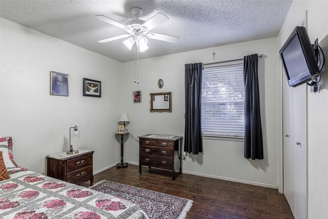 bedroom with ceiling fan, dark hardwood / wood-style flooring, and a textured ceiling