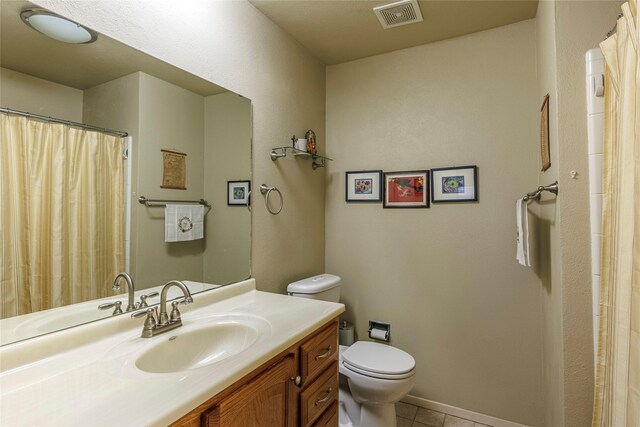 bathroom featuring tile patterned floors, vanity, and toilet