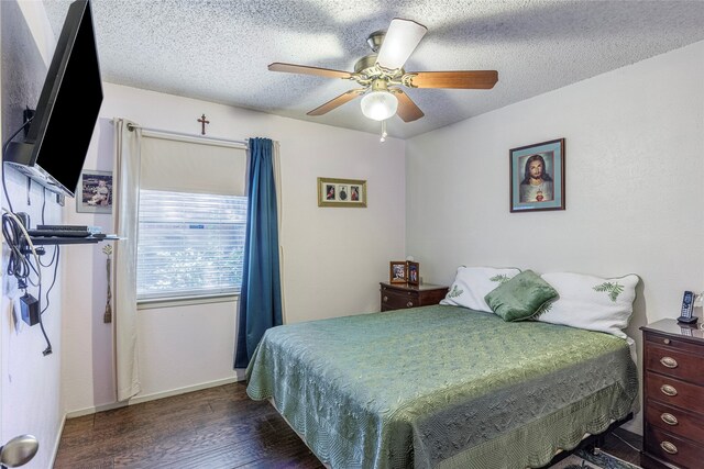 bedroom with a textured ceiling, ceiling fan, and dark wood-type flooring