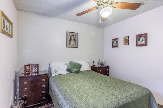 bedroom with ceiling fan and a textured ceiling