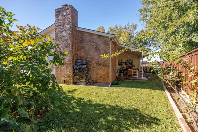 view of side of home with a patio area and a yard