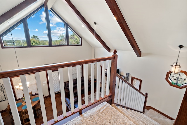 staircase featuring lofted ceiling with beams, hardwood / wood-style flooring, and an inviting chandelier