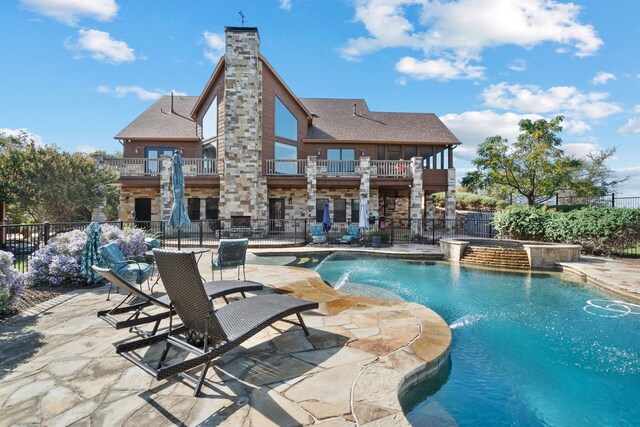 view of swimming pool with pool water feature, a patio area, and an in ground hot tub