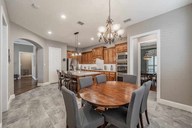 dining room with sink and a chandelier