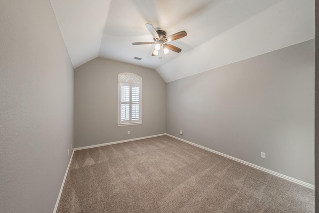 empty room featuring vaulted ceiling, carpet floors, and ceiling fan