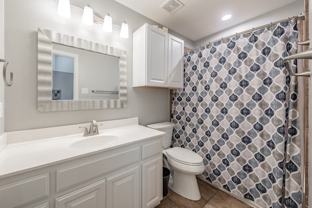 bathroom with tile patterned flooring, vanity, and toilet