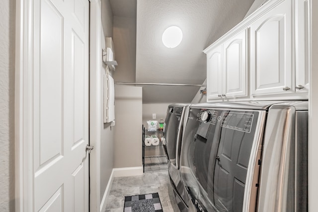 washroom featuring cabinets, separate washer and dryer, and a textured ceiling