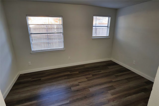 unfurnished room featuring plenty of natural light and dark hardwood / wood-style floors