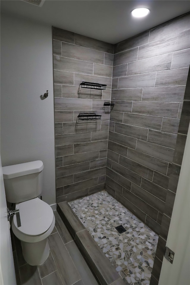 bathroom featuring toilet and tiled shower