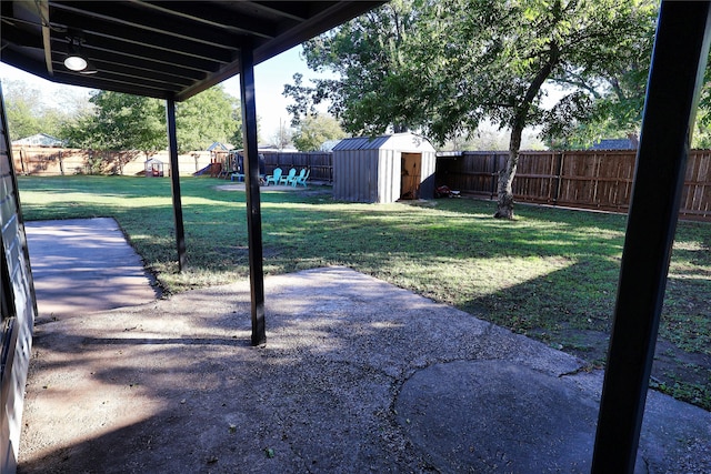 view of yard featuring a patio area, a playground, and a storage shed