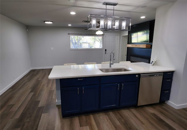 kitchen featuring dishwasher, blue cabinets, sink, and hanging light fixtures