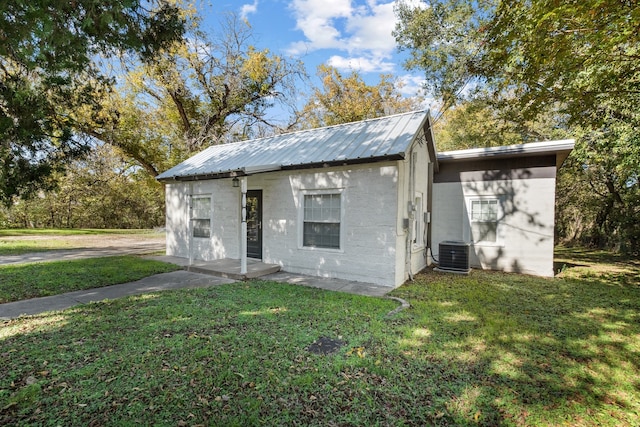 exterior space with central AC and a front lawn