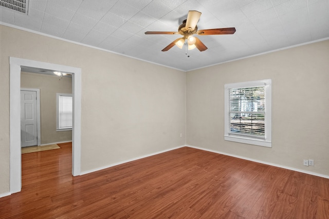 spare room featuring wood-type flooring, ceiling fan, and crown molding