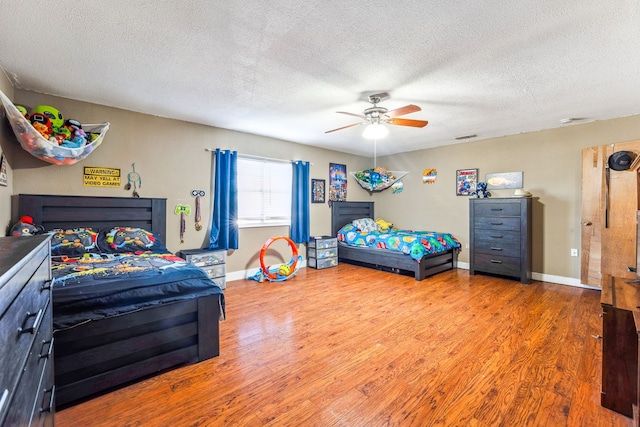 bedroom featuring wood-type flooring, a textured ceiling, and ceiling fan