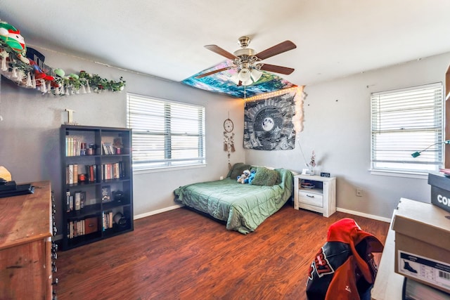 bedroom featuring ceiling fan, dark hardwood / wood-style floors, and multiple windows