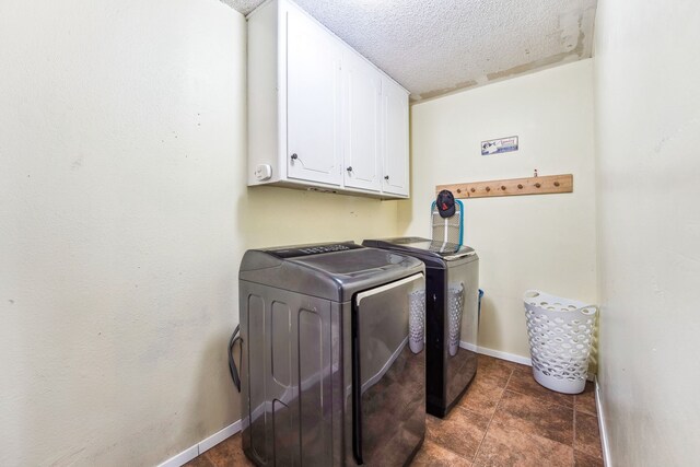 washroom with washer and dryer, cabinets, and a textured ceiling