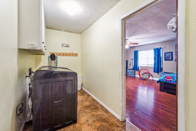 laundry area featuring washer hookup, a textured ceiling, ceiling fan, dark wood-type flooring, and water heater