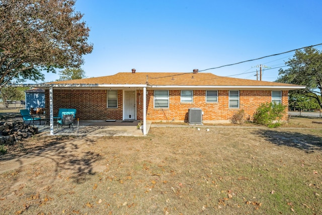 back of property with central AC unit and a patio