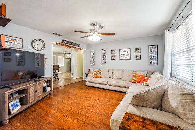 living room featuring ceiling fan, hardwood / wood-style floors, and a healthy amount of sunlight