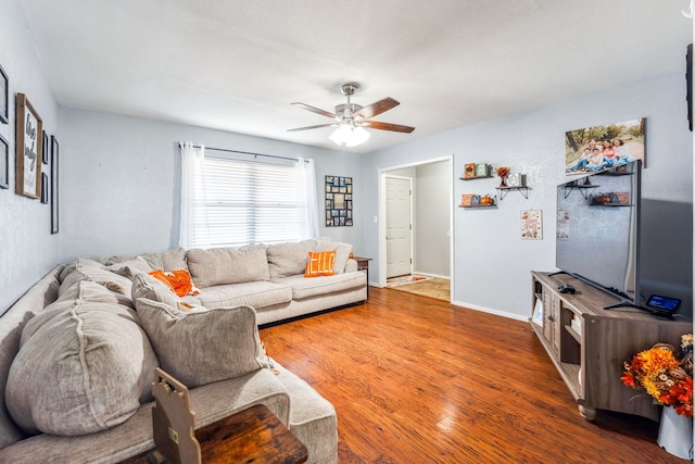 living room with dark hardwood / wood-style flooring and ceiling fan