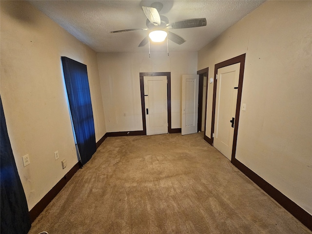 unfurnished room featuring a textured ceiling, ceiling fan, and light carpet