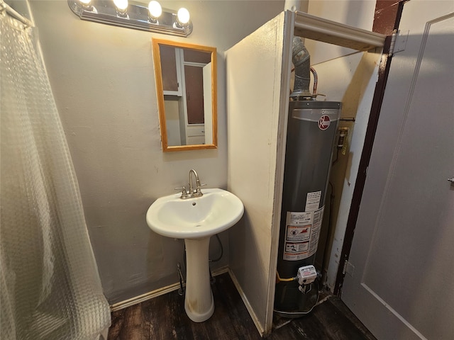 bathroom featuring hardwood / wood-style floors, gas water heater, and sink