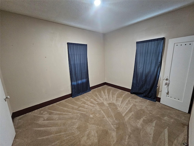 empty room with carpet flooring and a textured ceiling