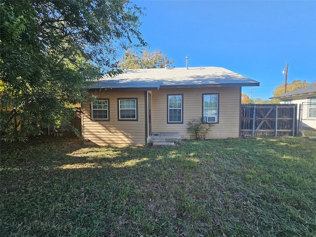 back of property with a lawn and cooling unit